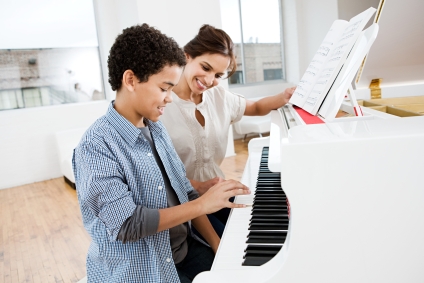Boy playing piano with teacher
