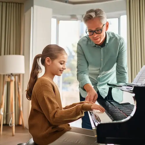 A young teenager from Atlanta is having piano lessons in her house with her piano teacher from Imagine Arts school