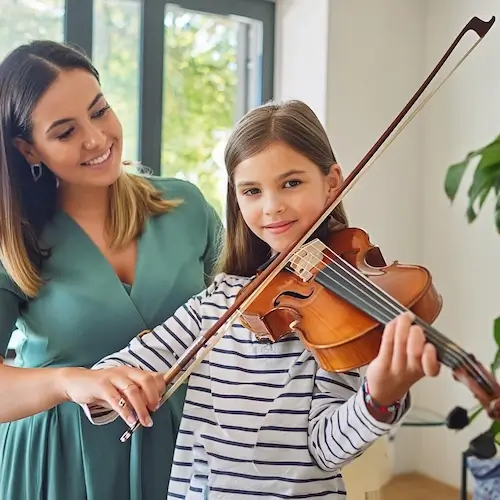 A young teenager from Atlanta is playing viola in her house while her viola teacher from Imagine Arts school is helping her 1